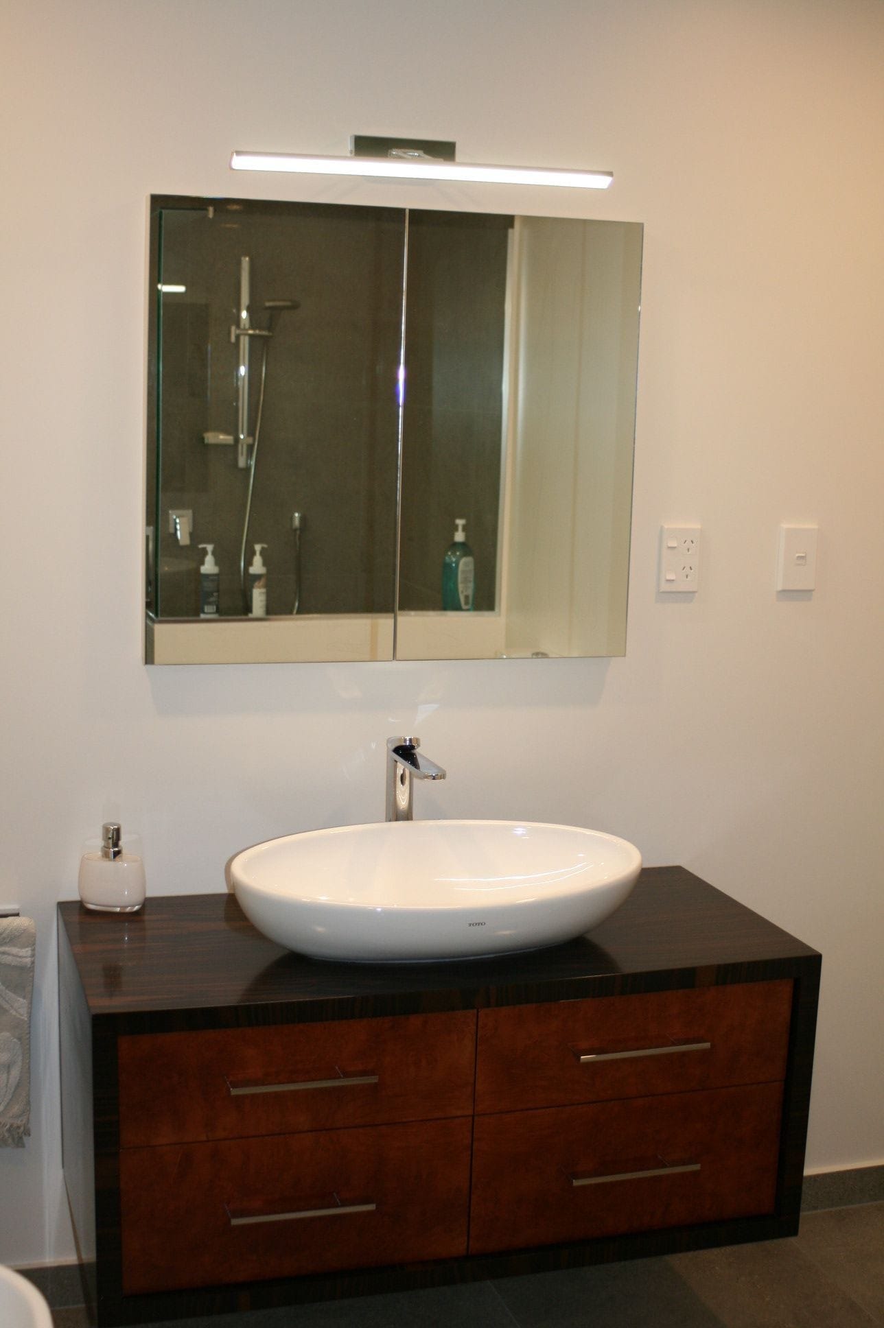 Macasa Ebony Vanity with Maple Burr drawer fronts. Wall mounted so vanity floats free from the floor. Toto basin and mixer.